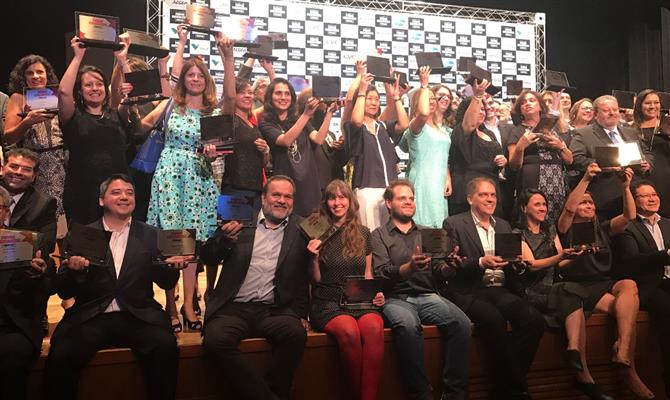 Parte dos premiados, incluindo Artur Luiz Andrade, da PANROTAS, e Adriana Moreira, do Estadão, sentados à frente