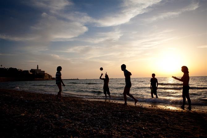 Turistas jogando vôlei em um final de tarde em Tel Aviv 
