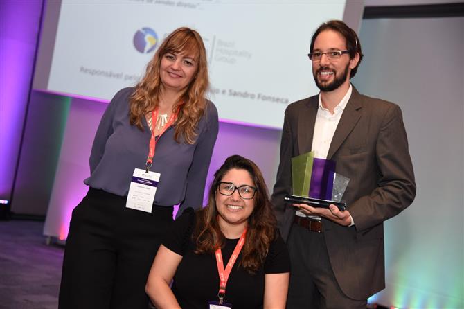 Gabriela Otto, da HSMai, entregou o prêmio a Juliana Silveira e Sandro Fonseca, da BHG