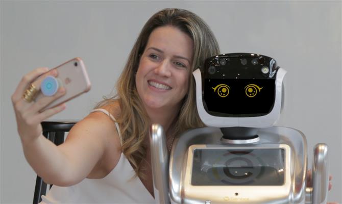 Fernanda Schaper, gerente geral do Ramada Encore Berrini, com o robô Rebeca