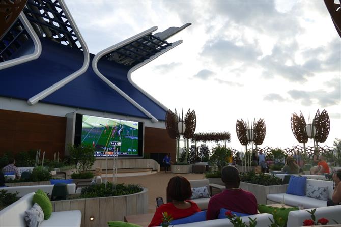 Rooftop Garde, lounge ao ar livre do Celebrity Edge, com telão para transmissões esportivas