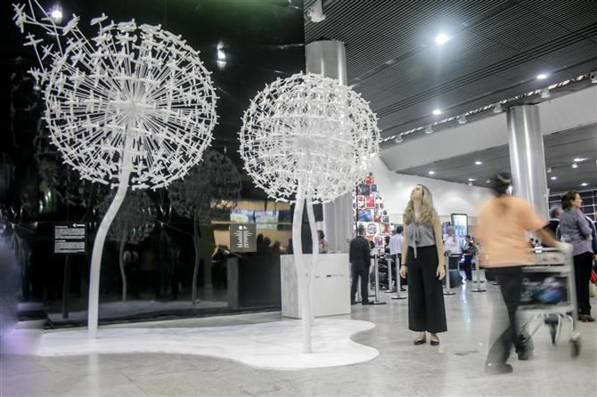Instalação artística conta com obra em alumínio que recria três flores dente-de-leão a partir de 480 maquetes brancas do Bandeirante, primeiro avião da Embraer