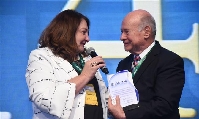 Magda Nassar, da Braztoa, recebe troféu com o presidente da PANROTAS, Guillermo Alcorta