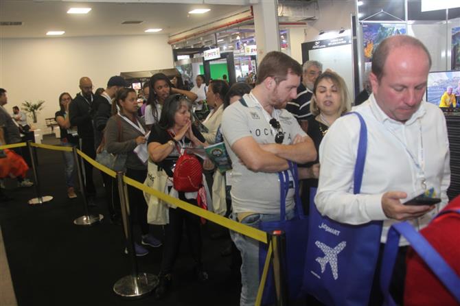 Fila de consumidores esperando por um agente de viagens. Bom público na Black Friday