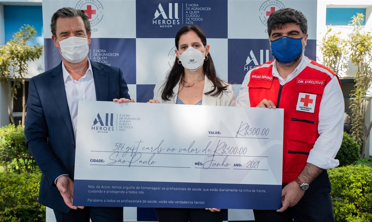 Thomas Dubaere e Roberta Vernaglia, da Accor, entregam cheque simbólico ao diretor executivo do Hospital Cruz Vermelha São Paulo, Bruno Semino