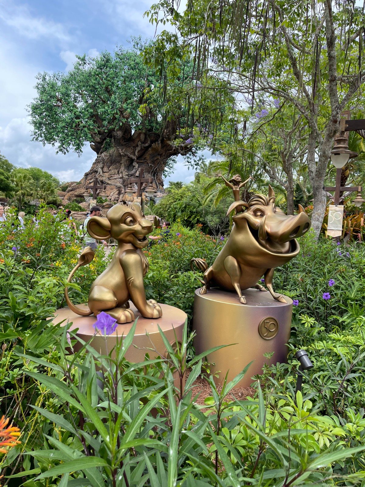 Estátuas douradas, como a que reúne Simba, Pumba e Timão em frente à Árvore da Vida, no Animal Kingdom, celebram os 50 anos de WDW