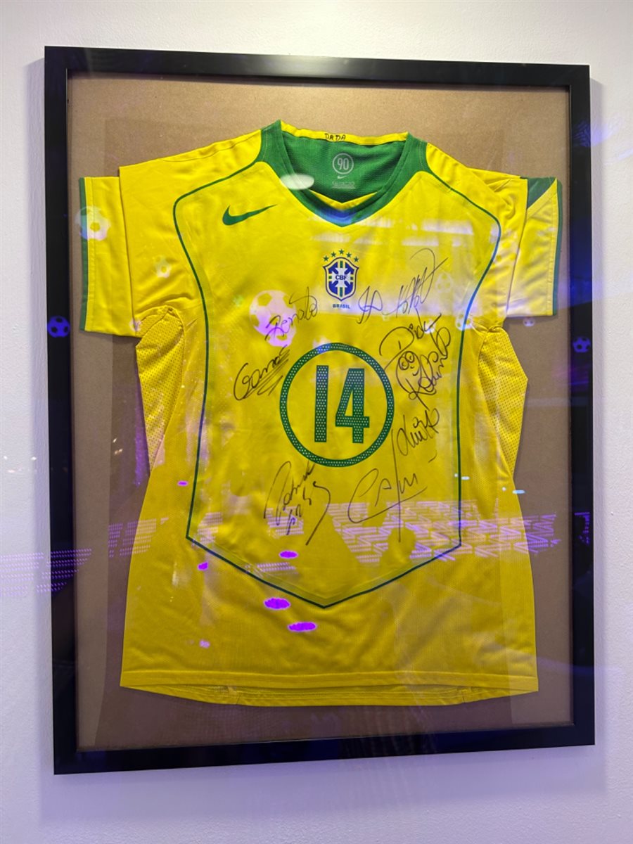Camiseta canarinho autografada por craques brasileiros exposta na Qatar Airways House