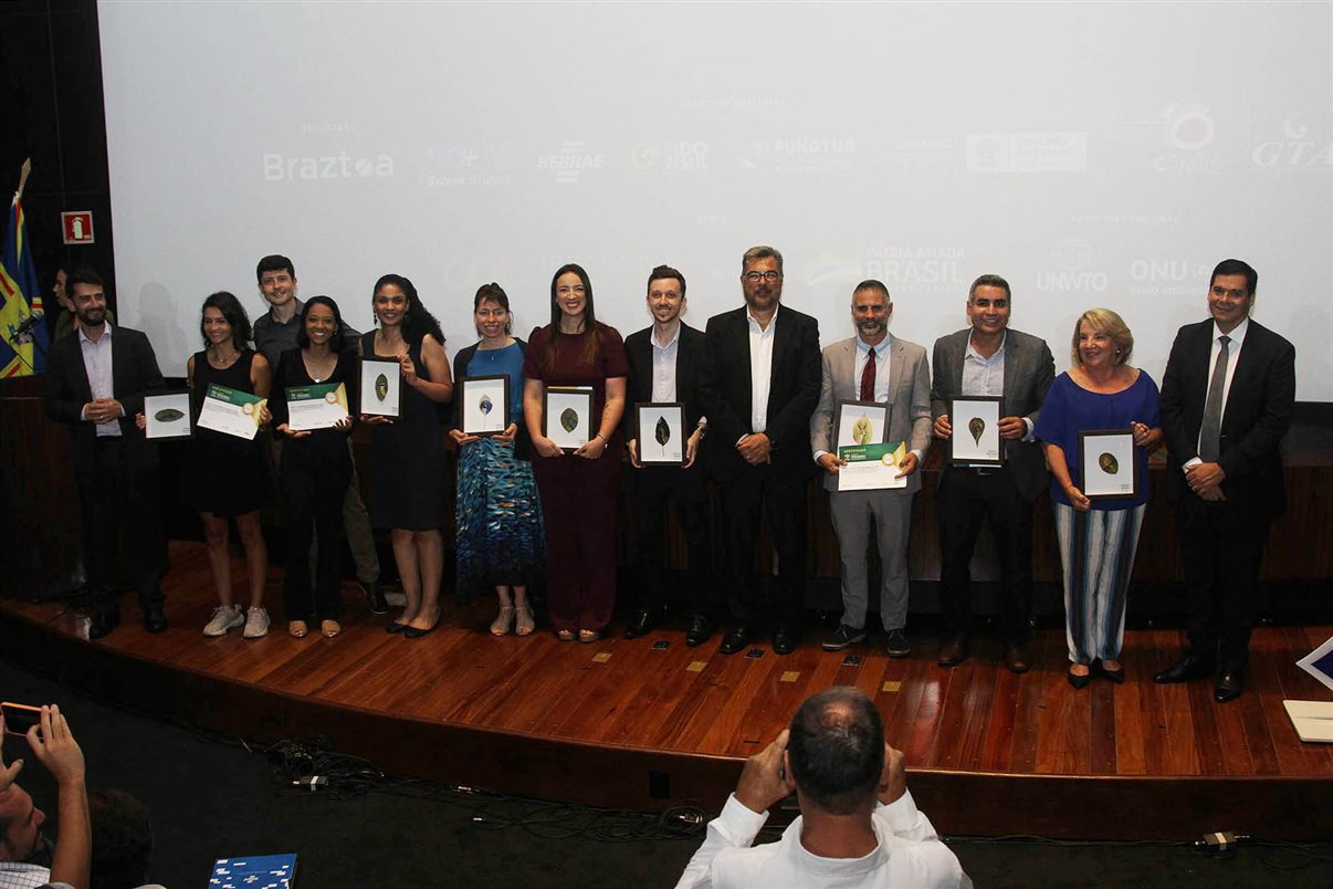 Vencedores do Prêmio Braztoa de Sustentabilidade posam para foto no palco do auditório do Bioparque Pantanal em Campo Grande (MS)