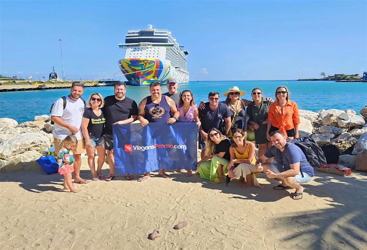 Grupo de agentes de viagens posa em frente ao navio Norwegian Encore em Puerto Plata, na República Dominicana