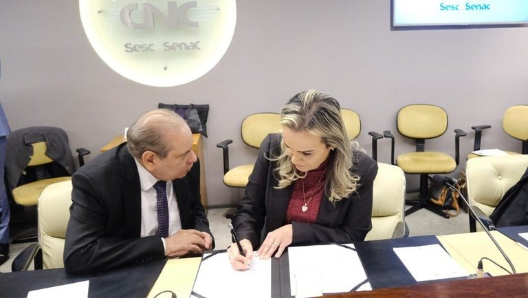 José Roberto Tadros, presidente da CNC, e Daniela Carneiro, ministra do Turismo, assinam acordo