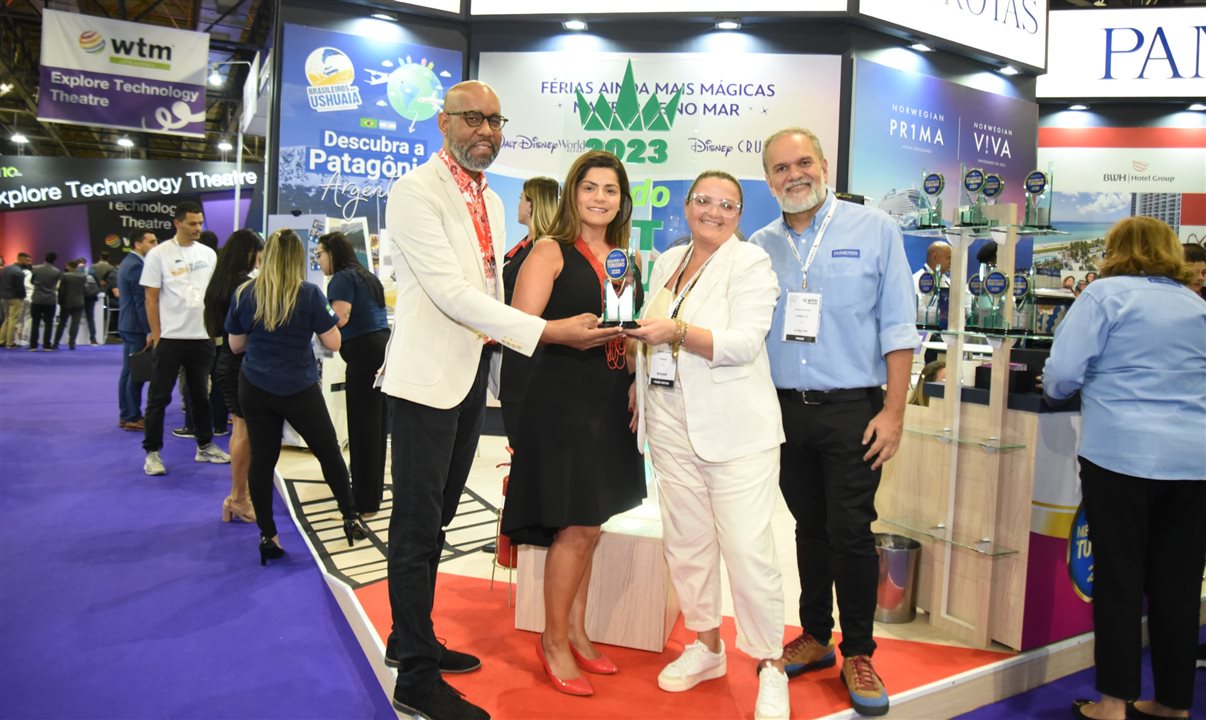 Andre Rojer, Janaina Araújo, de Curaçao, e Artur Andrade, da PANROTAS, entregam troféu do Melhores do Turismo 2023 para Daniela Araújo, da Decolar, como melhor OTA