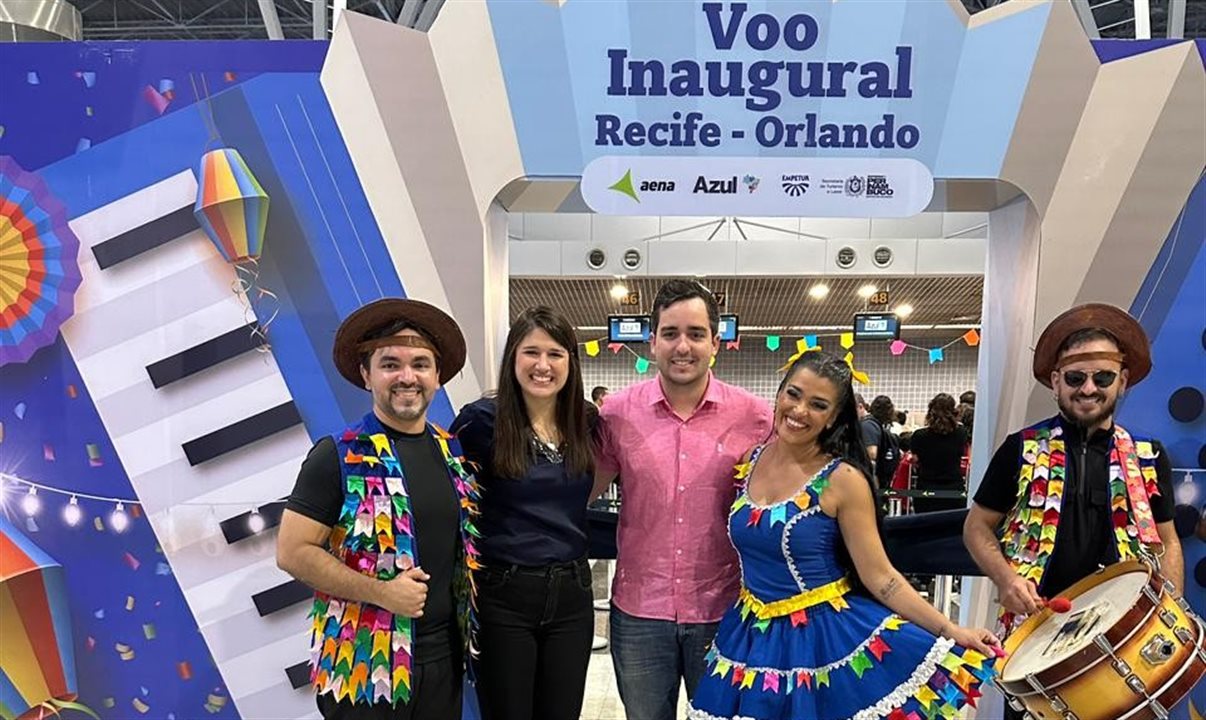 Cacau de Paula, da Setur do Recife, e Eduardo Loyo, presidente da Empetur, entre músicos, comemoram a reinauguração do voo entre Recife e Orlando com a Azul