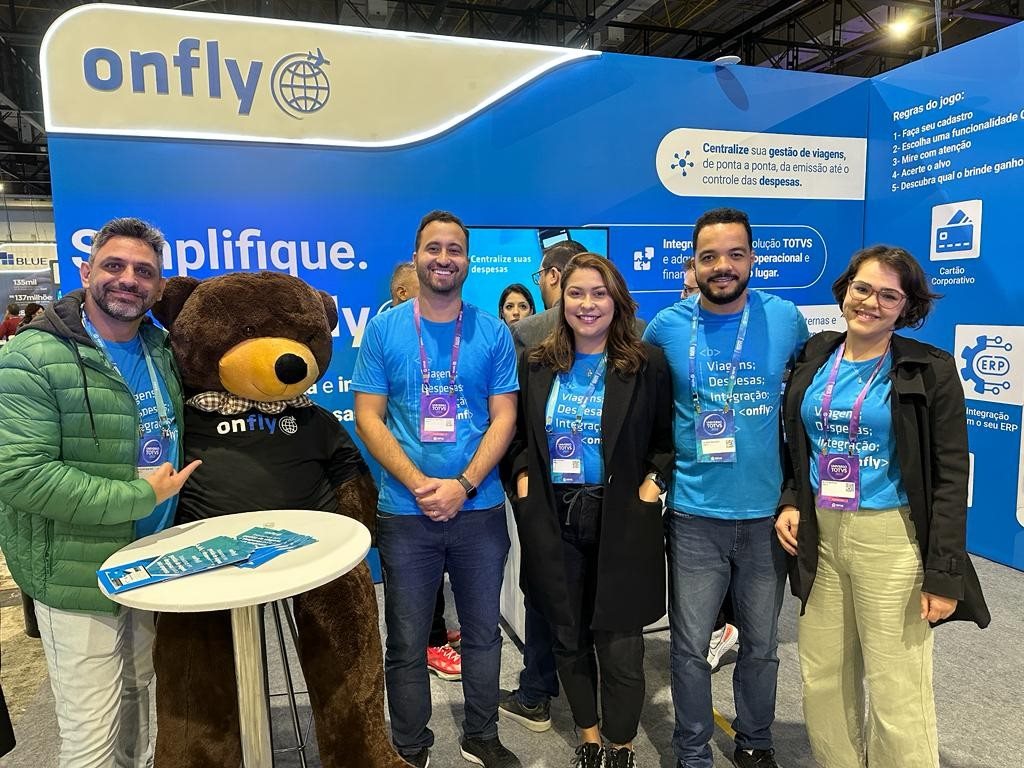 Parte da equipe Onfly no Universo Totvs 2023: Cláudio Martins, o urso mascote da empresa, Marcelo Linhares, Natália Maia, Aloísio Macedo e Alice Mairink