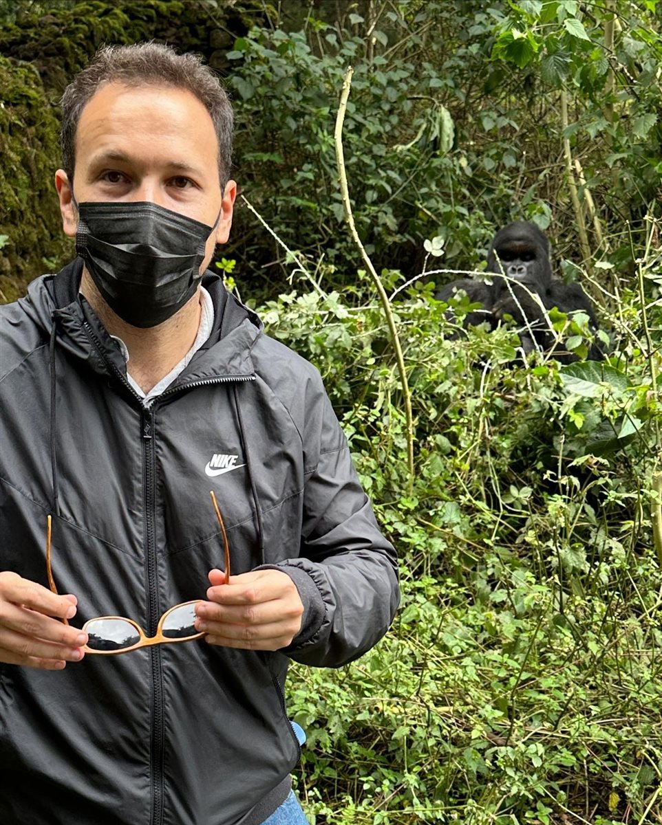 Rodrigo Vieira, da PANROTAS, na montanha em frente ao gorila silverback da família Susa