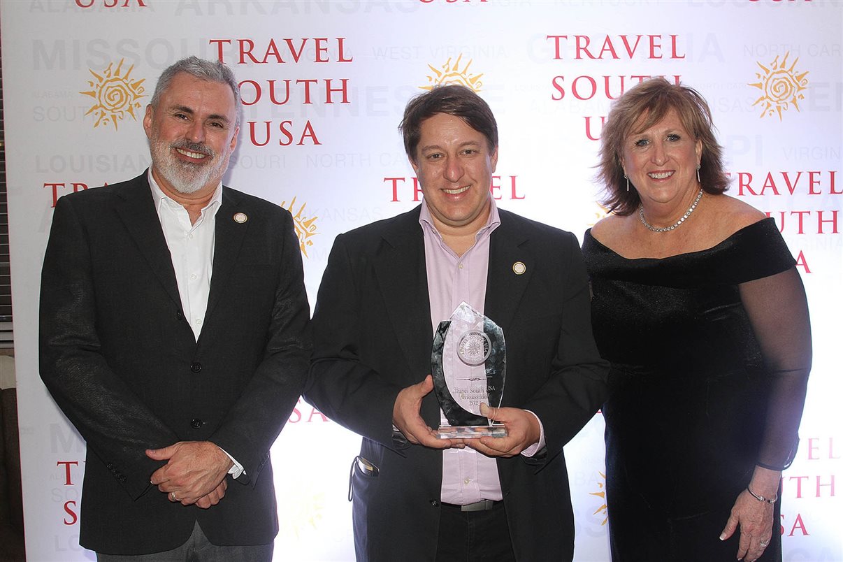 Charles Franken, da Diversa, entre Allan Colen e Liz Bittner, da Travel South USA, com troféu que recebeu pela sua contribuição para o Turismo do sul dos Estados Unidos