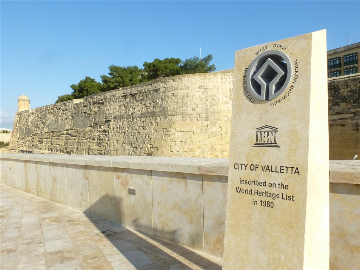A entrada da cidade velha de Valeta, com parte da antiga fortificação e o selo da Unesco