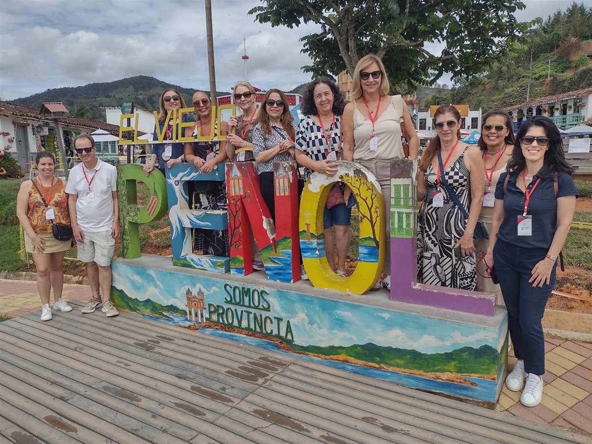 Grupo da Flot posa no letreiro turístico da cidade de El Peñol, a 2h de Medellín