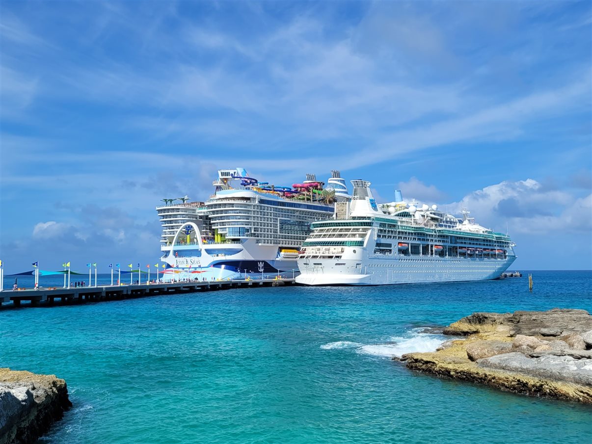 Foto feita pela jornalista PANROTAS Karina Cedeño também serve como comparativo: Icon of the Seas (2023) ao lado do Enchantment of the Seas, de 1997. eles estão atracados na ilha Perfect Day At Cococay, ilha exclusiva da Royal Caribbean nas Bahamas