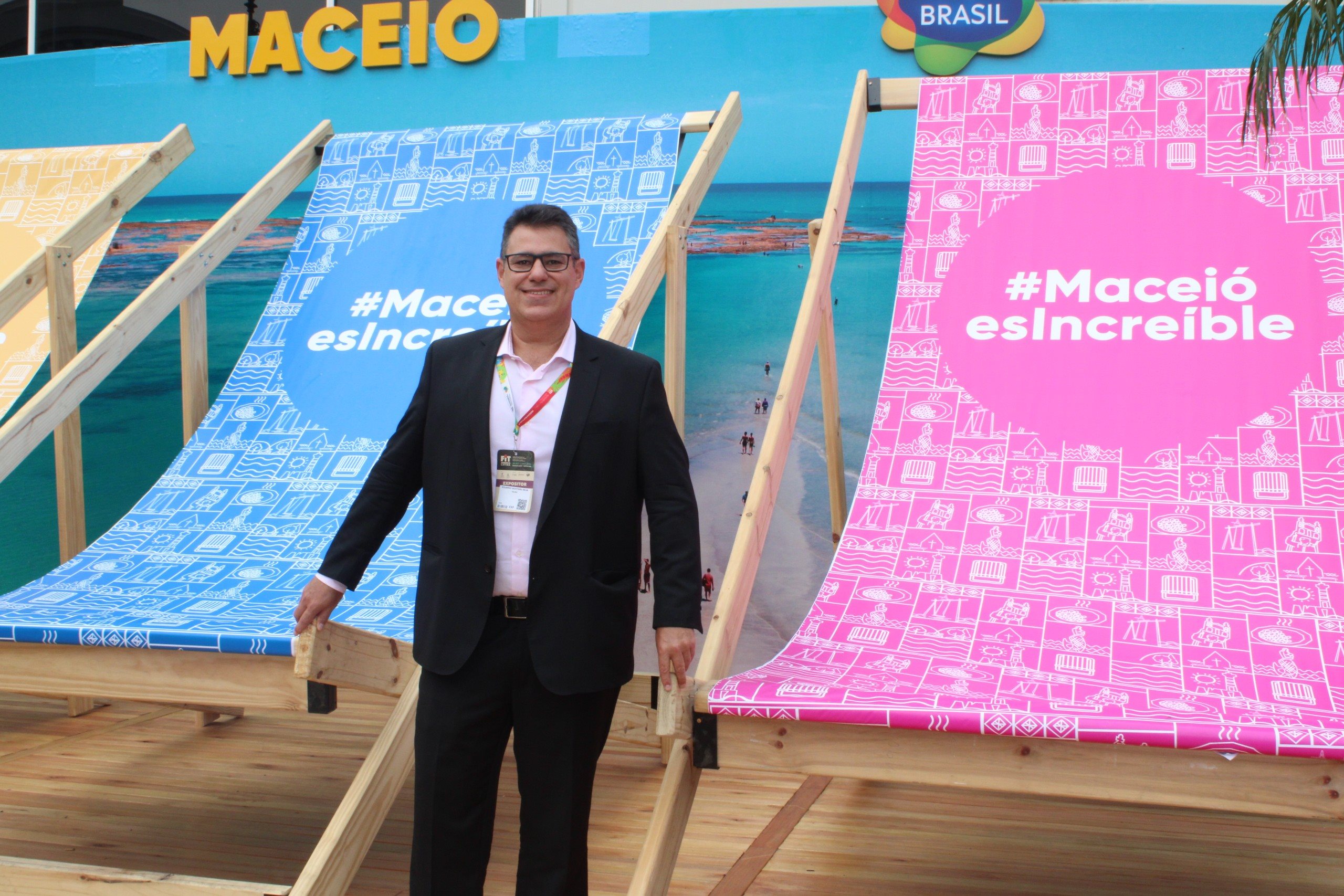 Eduardo Monteiro, secretário de Turismo de Maceió, em frente as cadeiras de praia gigantes que fazem parte da ação do destino na FIT 2024