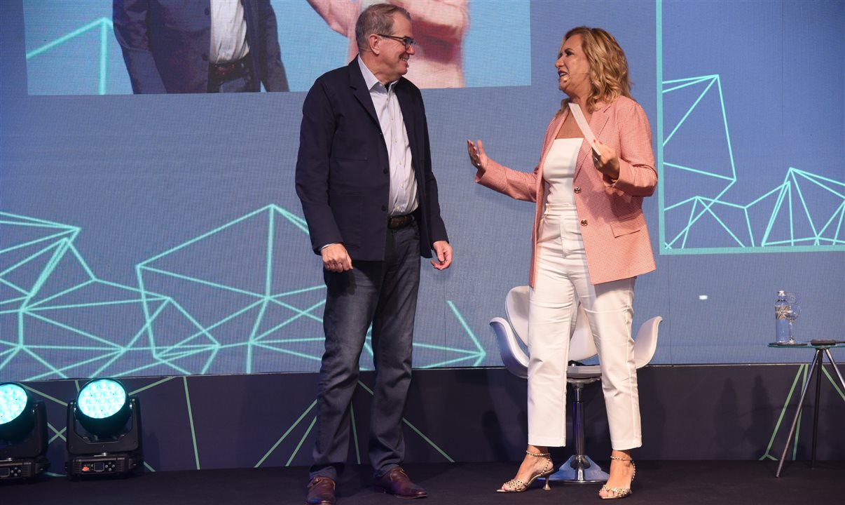 Greeley Koch e Vivi Martins, da Academia de Viagens Corporativas, no palco durante o Download 2023