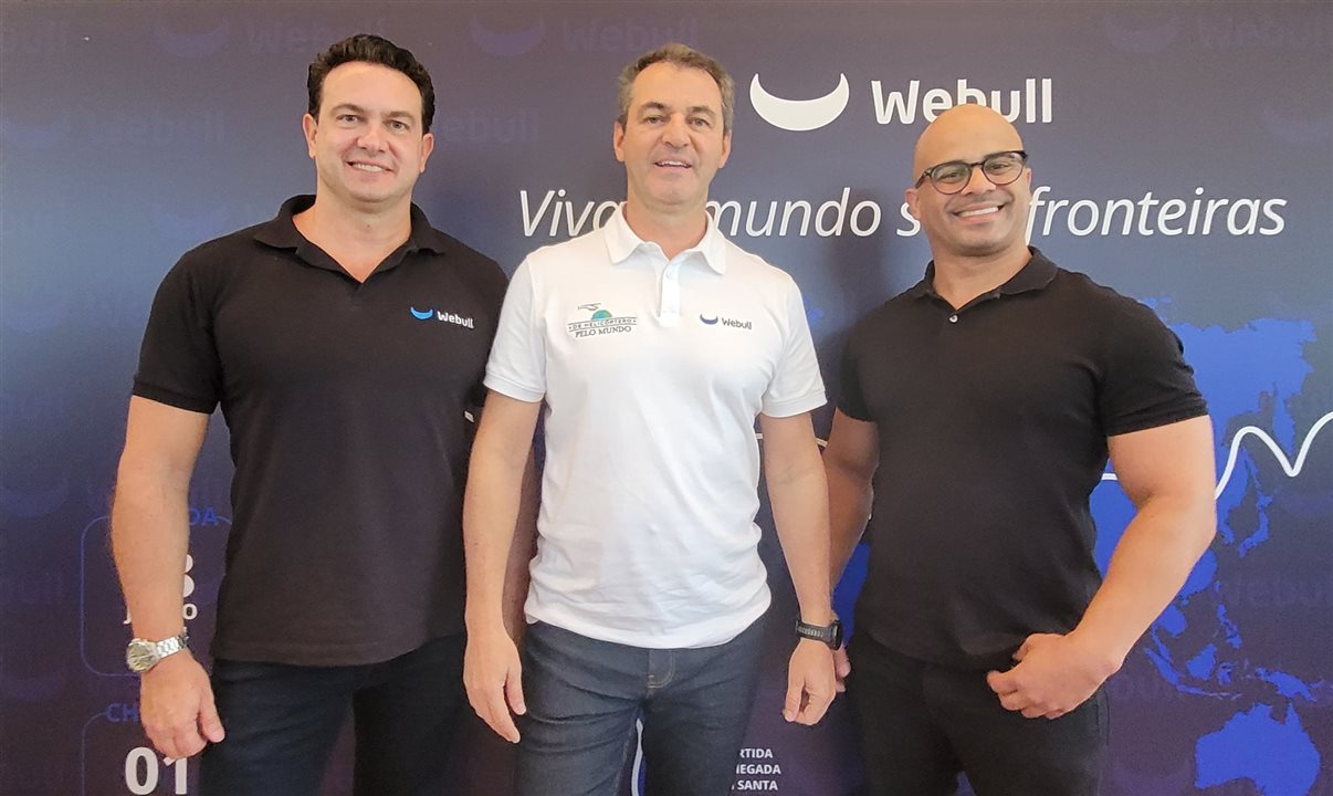 André Freitas, viajante global que rodou o mundo de helicóptero, em meio a Fabio Trevisan e Ruben Guerrero, ambos da Webull