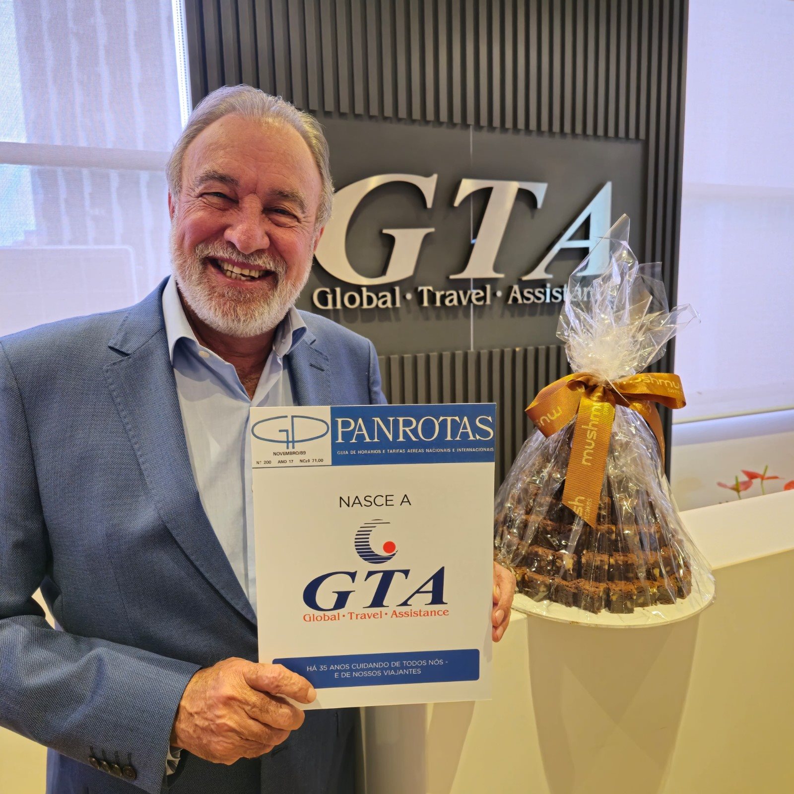 Celso Guelfi, presidente da GTA, com o bolo de aniversário e exemplar especial do Guia PANROTAS