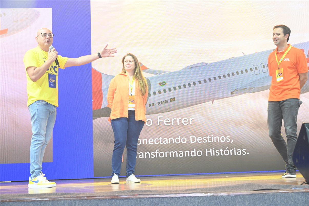 Fabio Mader, da CVC Corp, no palco com Carla Fonseca e Celso Ferrer, da Gol