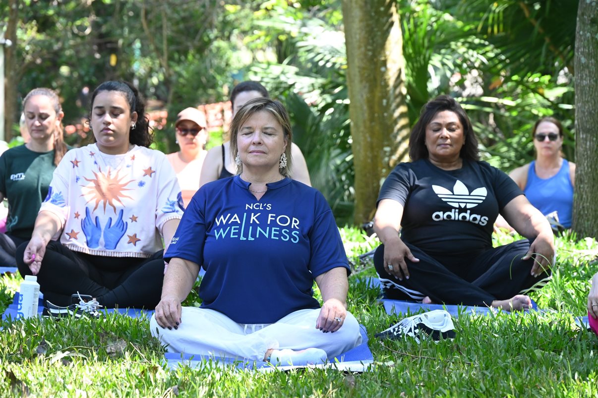 Estela Farina, diretora da NCLH no Brasil, com parceiros em sessão de yoga