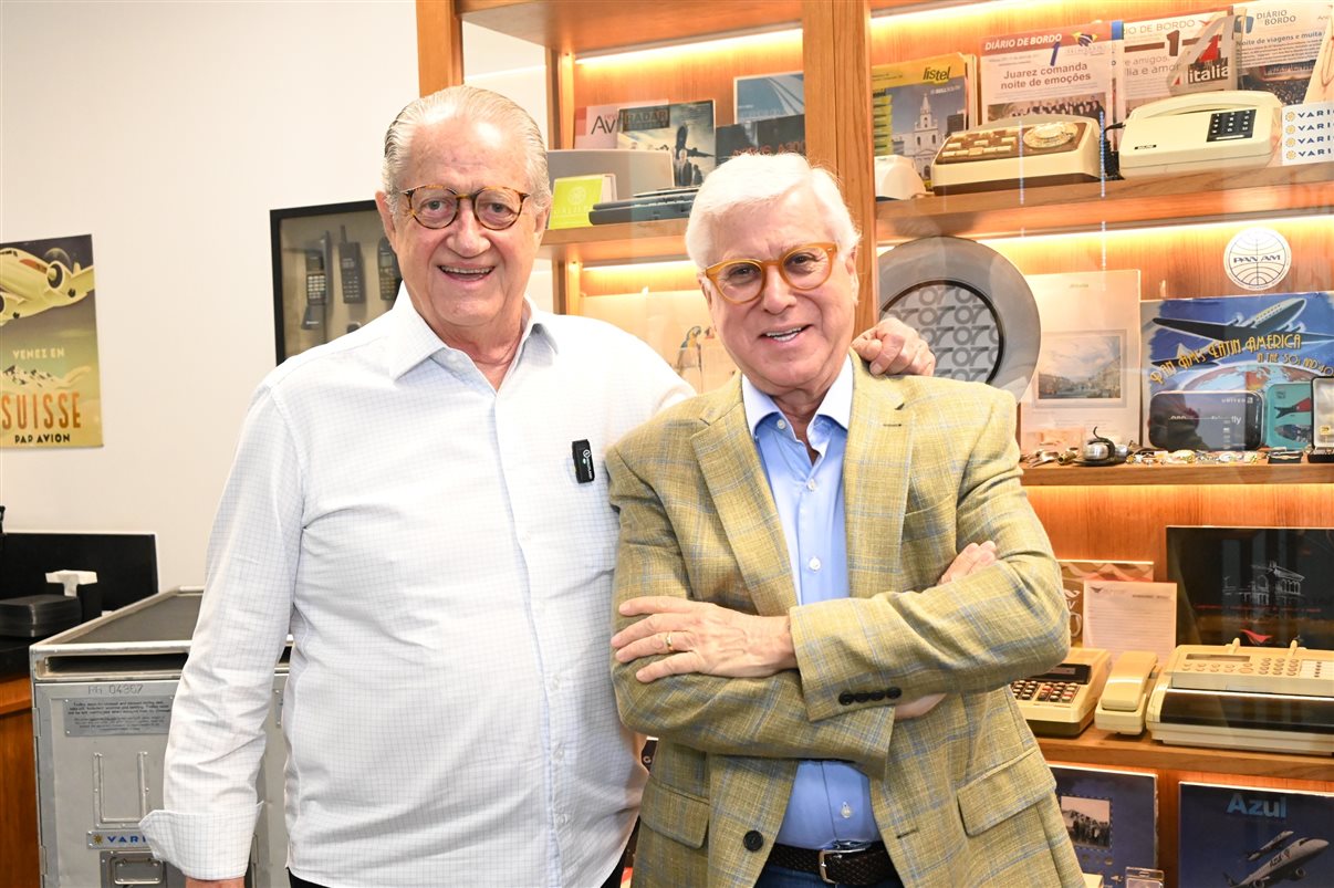 Leonardo Coutinho e Juarez Cintra, da Ancoradouro, celebraram em transmissão ao vivo com a Espanha a inauguração da Sala 120 do Museu do Turismo; ao fundo, a vitirine que reúne o acervo