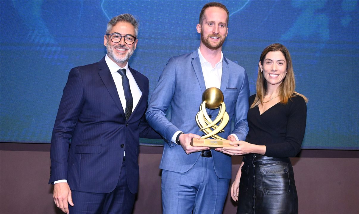 Humberto Cançado, da Voetur Turismo, entrega o prêmio a Camilo Crozet e Fernanda Garrido, da rede Hyatt