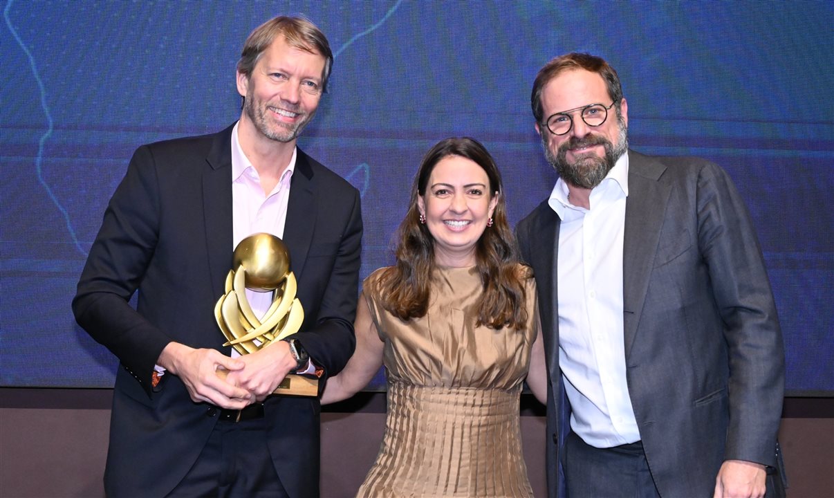 Luciano Guimarães, da BeFly, entrega o prêmio a Jerome Cadier e Aline Mafra, da Latam