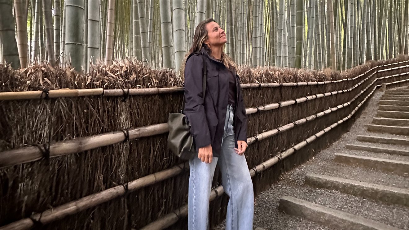 Juliana Gallo, da Embarque With Us, contemplando a floresta de bambu em Quioto