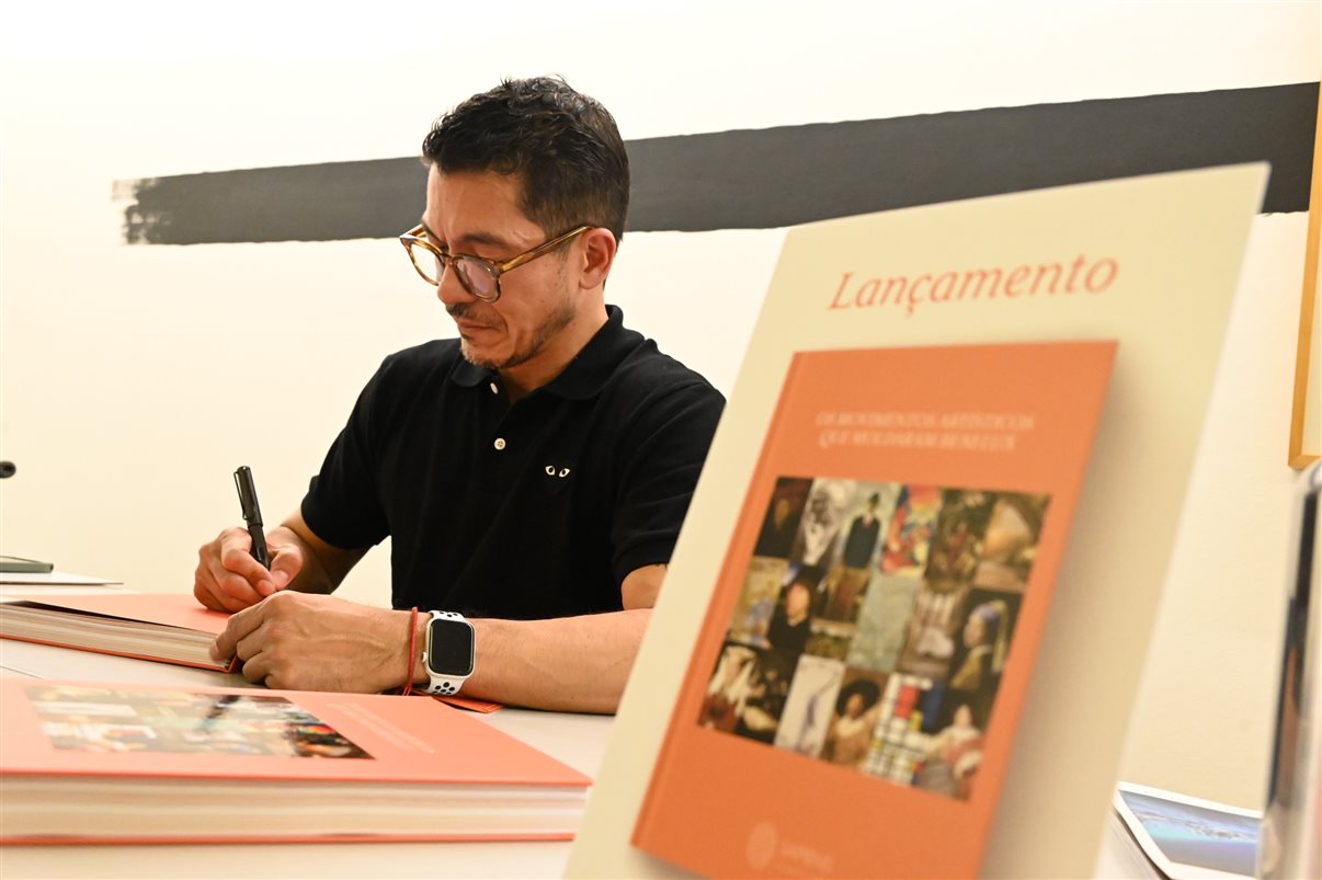 Erik Sadao faz dedicatória do livro Os Movimentos Artísticos que Moldaram Benelux