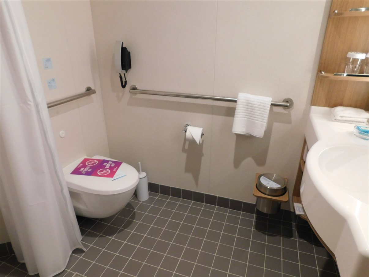 Banheiro de cabine com acessibilidade tem barras de apoio para dar mais seguran&ccedil;a e conforto aos h&oacute;spedes