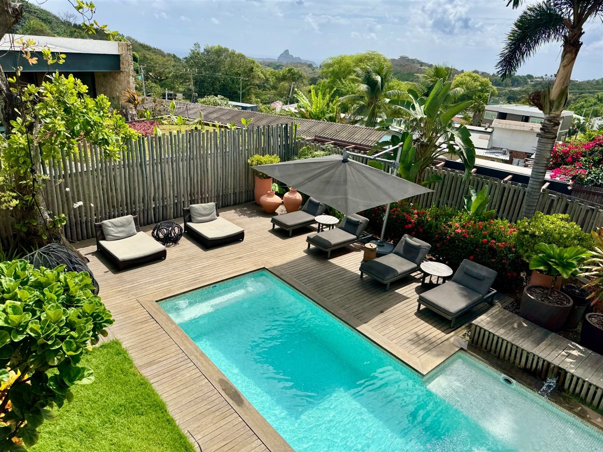 Piscina e espreguiçadeiras vistas da varanda de um dos quartos