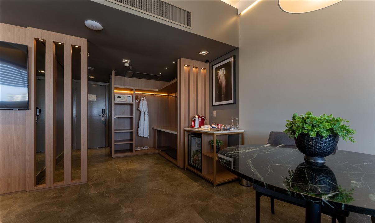 Suíte tem Smart TV de 49 polegadas, sofá, mesa de trabalho e mesa de jantar