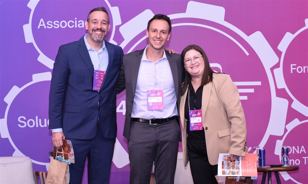 Erika Moraes e Gustavo Santana, da Meliá Hotels International, no palco com Bruno Waltrick