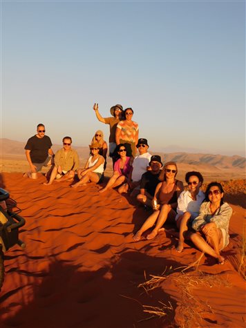 Grupo da Flot recebe luz do p&ocirc;r do sol em duna da reserva do hotel The Desert Grace