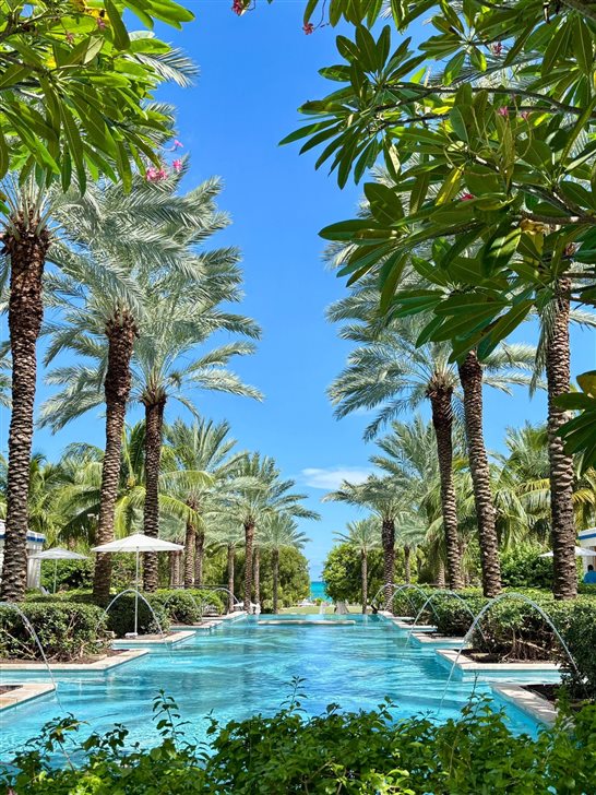 Piscina cercada de palmeiras no resort Baha Mar, em Cable Beach