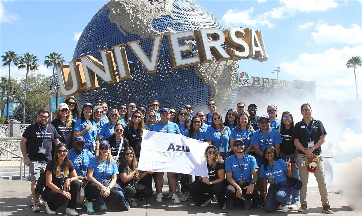 Grupo de agentes da Azul Viagens posa em frente ao globo da Universal