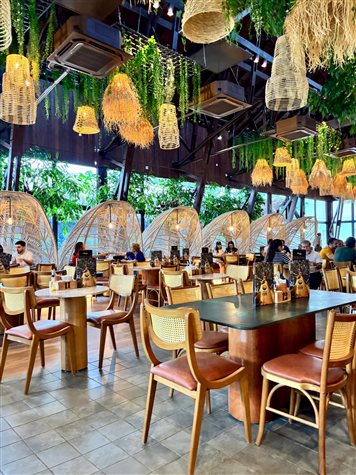 Sal&atilde;o do restaurante onde entradas e pratos principais s&atilde;o servidos em cuias