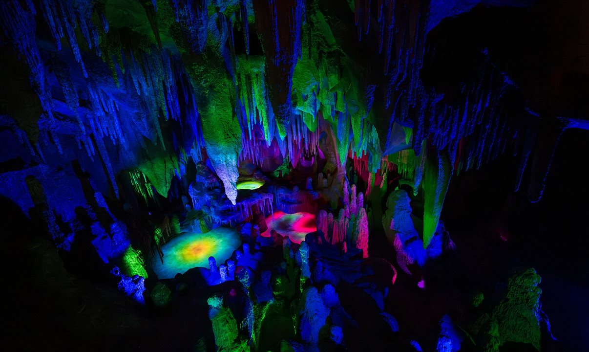 Trajeto da montanha-russa tem estalagmites iridescentes e estalactites que brilham