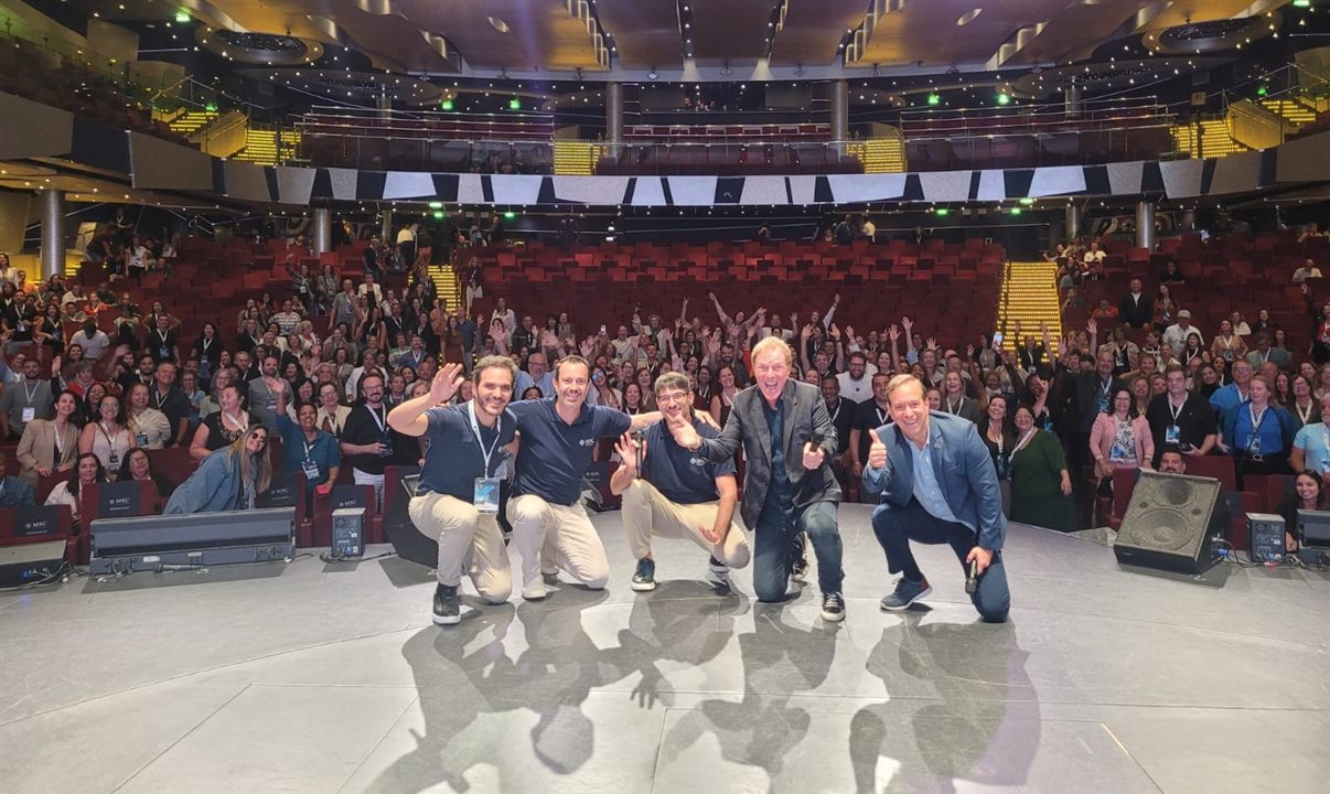Rafael Grosso, Eduardo Simões, Ignacio Palacios, da MSC Cruzeiros, o palestrante Ciro Bottini e Adrian Ursilli, da MSC Cruzeiros, ao final da convenção, com os agentes de viagens ao fundo