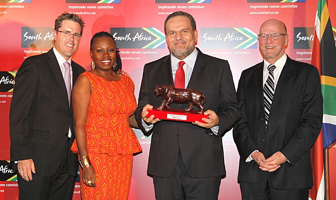 O editor-chefe da PANROTAS, Artur Luiz Andrade, recebe o prêmio Ubunto, simbolizado pelo leopoardo, um dos Big 5 da África do Sul, do ministro Derek Hanekom (à direita) e de autoridades da SAT
