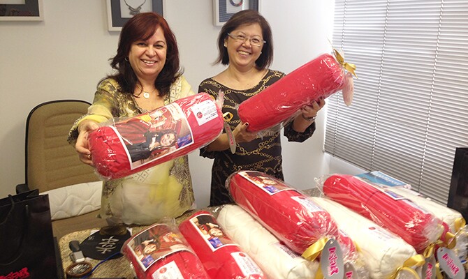 Deusa Rodrigues e Olga Arima seguram o presente que está sendo dado aos clientes