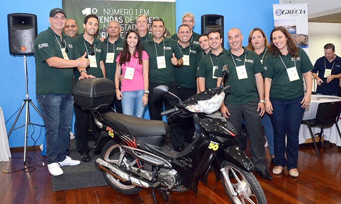 Eduardo Aoki com o time da Intermac e a moto que foi para uma agente de viagens