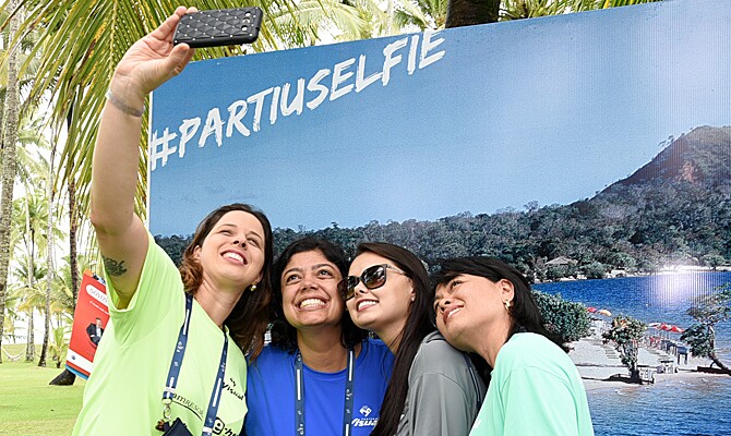 Amanda Arantes, da Mania de Viagem, Elisa Magalhães, da Trajetus, Gabriela Braga, da Turismus, e Aladia Costa, da All Time registram selfie no painel do Ministério do Turismo